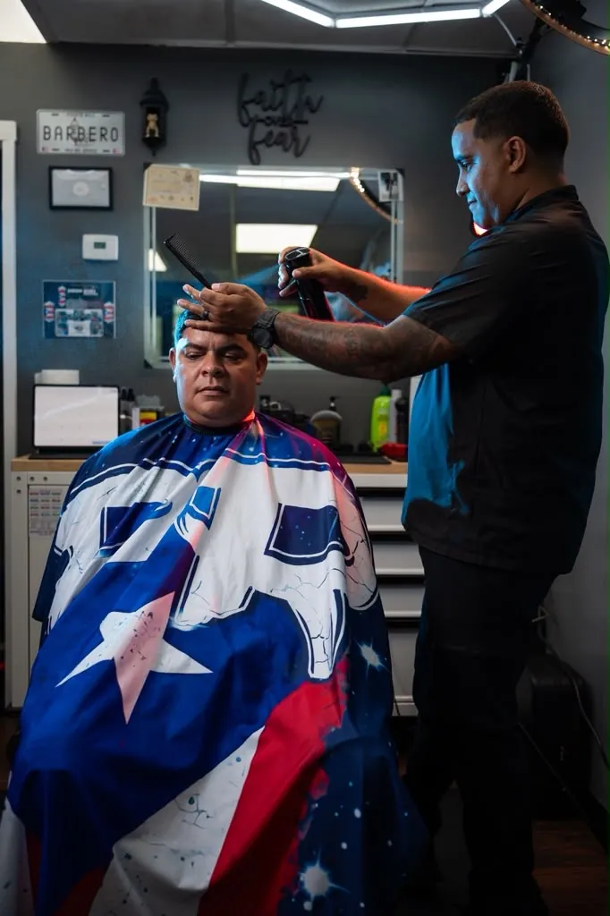 Fade in progress on a client wearing the Puerto Rican flag cape